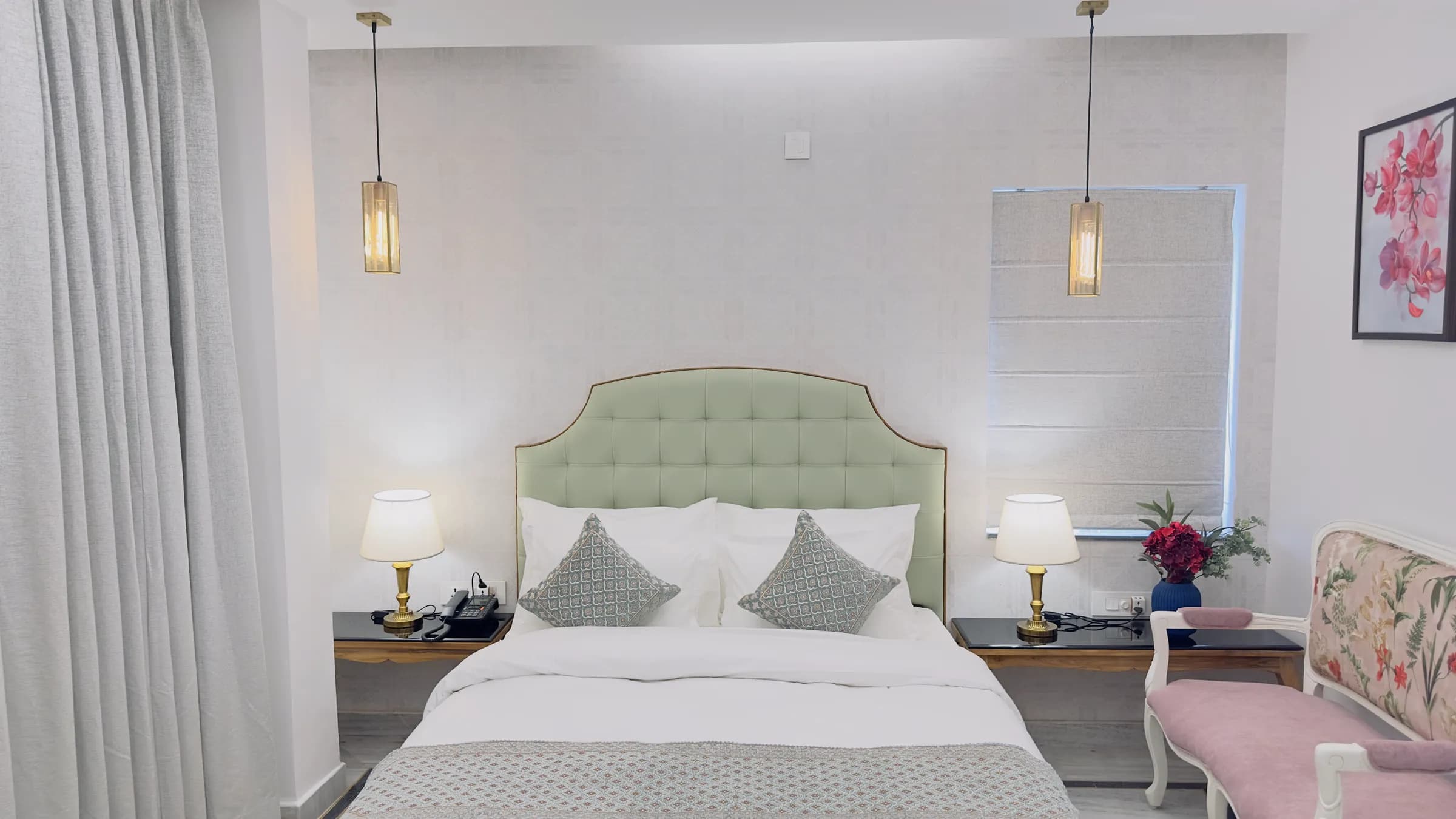 Elegant Oasis with Gallery at The Mohua, with a sage headboard, white linen, hanging lights and a floral sofa